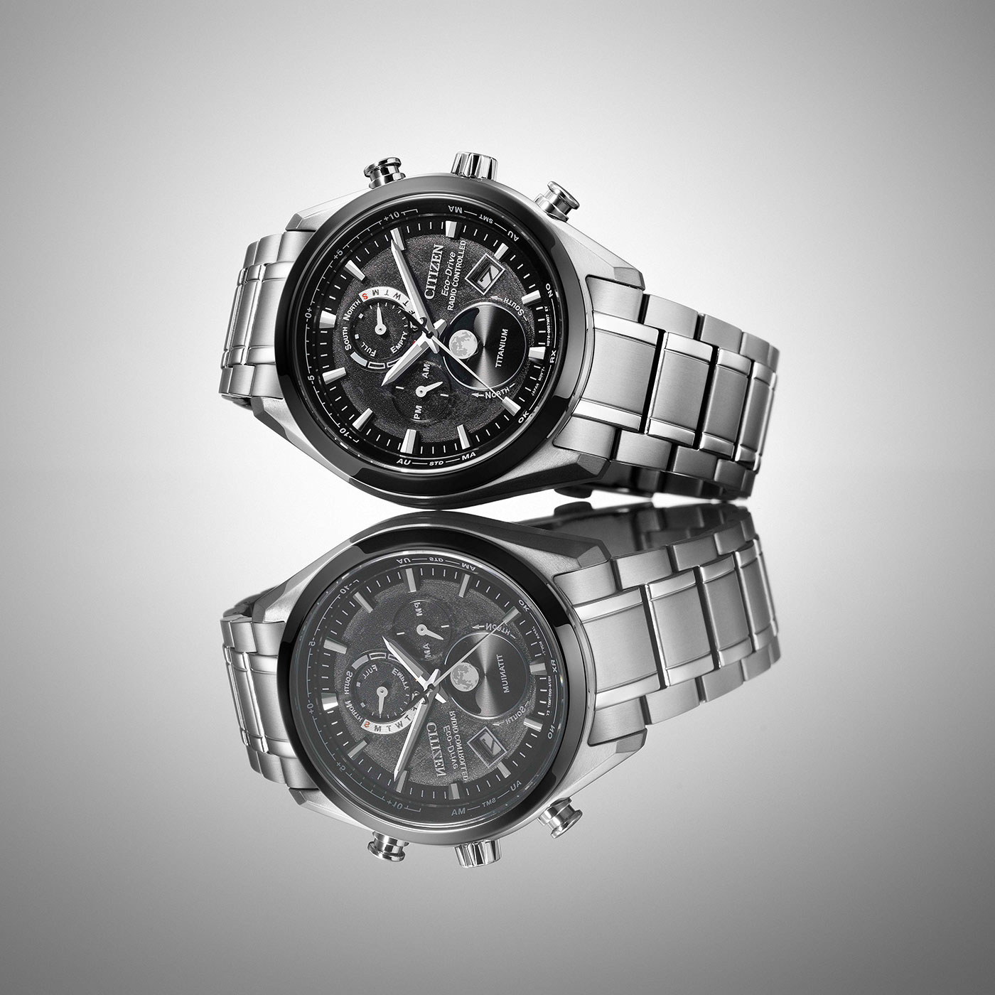 Citizen-Uhr mit schwarzem Zifferblatt und silbernem Armband, reflektiert auf einer Oberfläche.