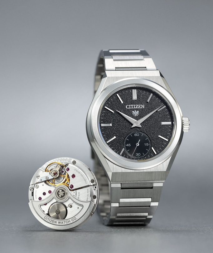 This image features a Citizen watch with a silver-toned integrated bracelet and a textured black dial. Beside it, the intricate mechanical movement is displayed, revealing gears and jewels, highlighting both the watch's elegant design and precise interna