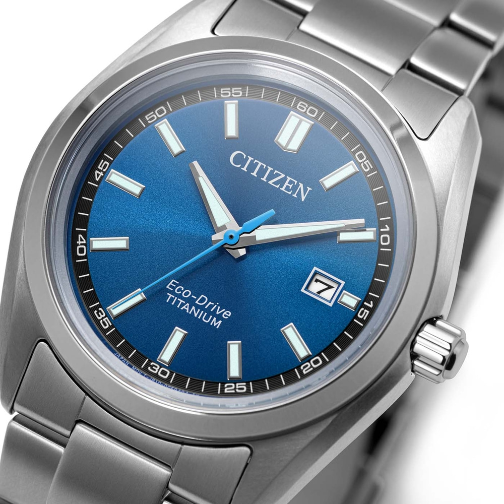 Eine Nahaufnahme einer Citizen Eco-Drive Titan Uhr mit blauem Zifferblatt und silbernem Band.