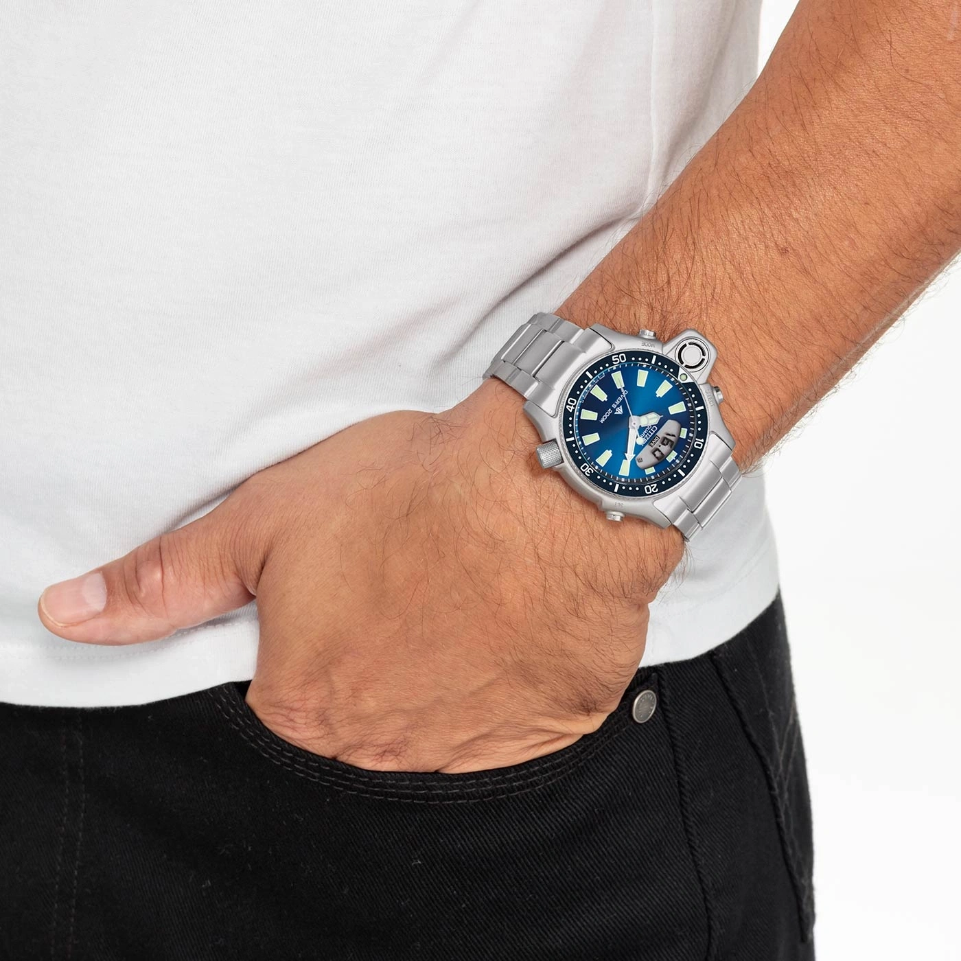 Mann trägt silberne Uhr mit blauem Zifferblatt, Hand in der Tasche.