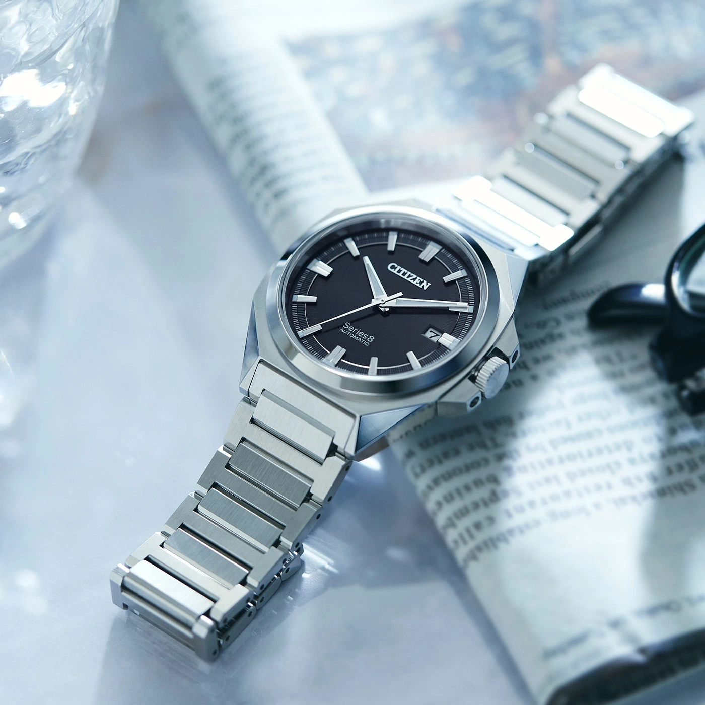 Citizen Series 8 Uhr auf Zeitung, schwarzes Zifferblatt, silbernes Armband, elegantes Design