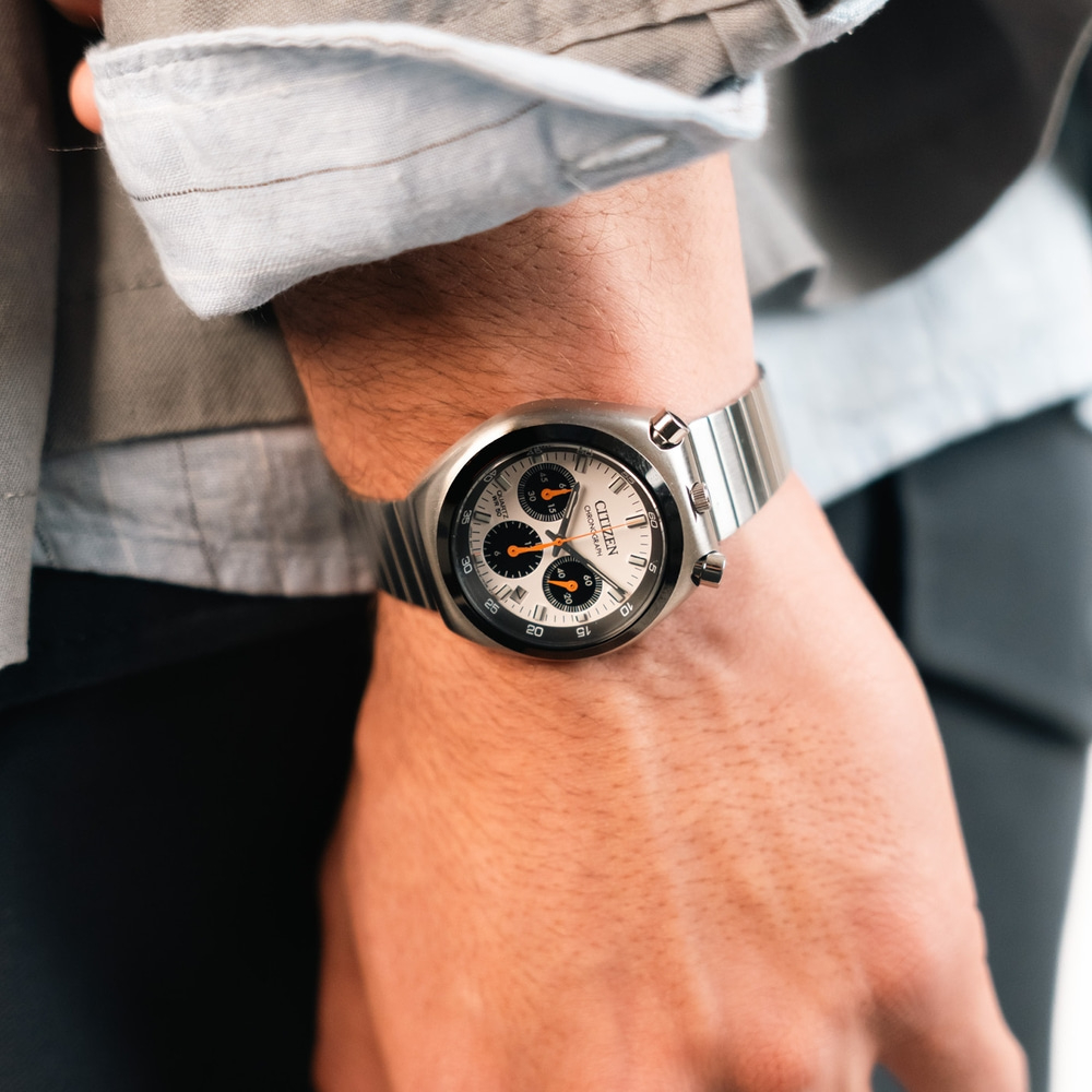 Ein Mann trägt eine silberne Citizen Chronographen-Uhr.
