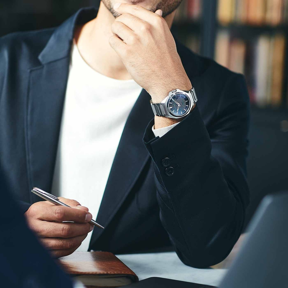 Mann im Anzug mit Uhr, hält Stift, denkt nach, Geschäftstreffen, Büro