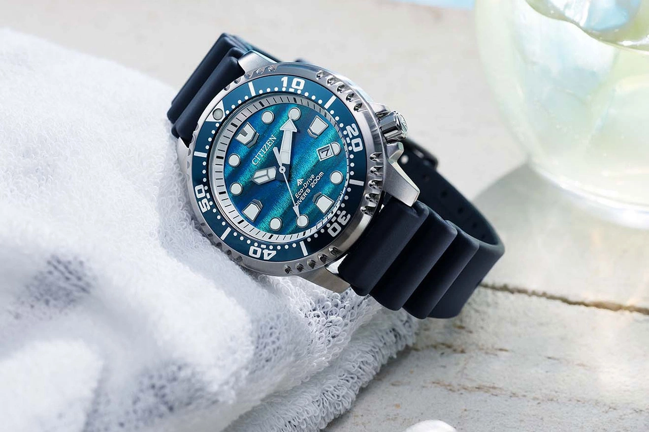 Eine blaue Citizen Eco-Drive Taucheruhr mit Kautschukarmband liegt auf einem weißen Handtuch.