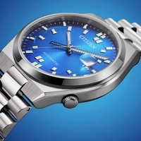 Nahaufnahme einer blauen Citizen Automatik-Uhr mit Metallarmband.