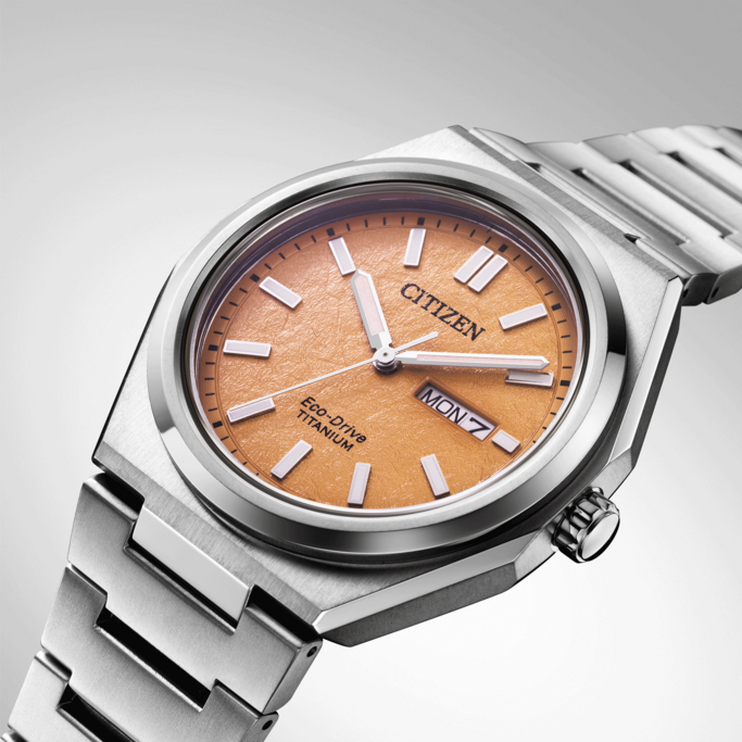 Citizen-Uhr mit orangefarbenem Zifferblatt und Titanband, Eco-Drive-Technologie.