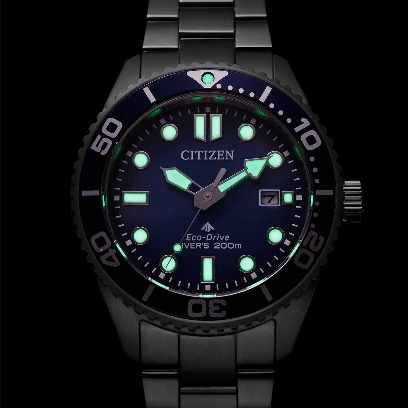 Citizen-Uhr mit leuchtenden Zeigern und Markierungen, schwarzer Lünette, blauem Zifferblatt und Datumsanzeige.