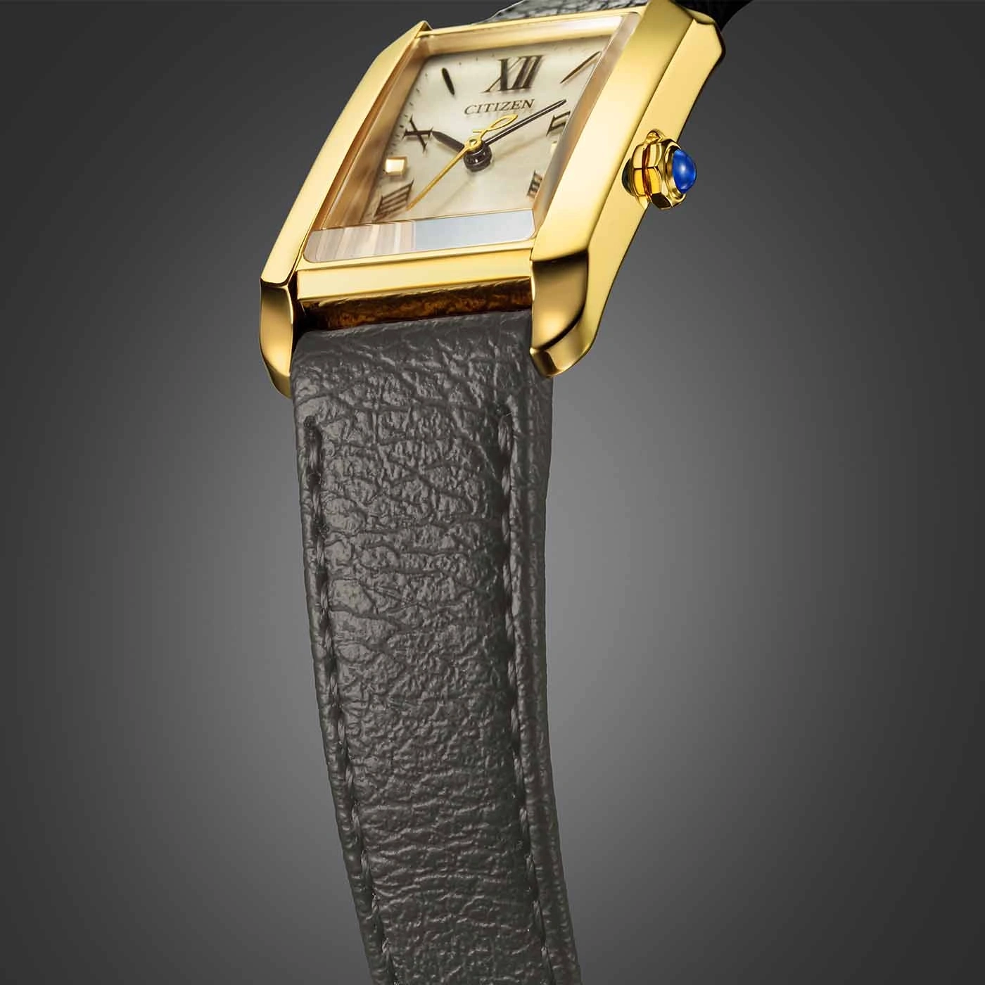 Goldene Uhr mit rechteckigem Zifferblatt und Lederarmband.