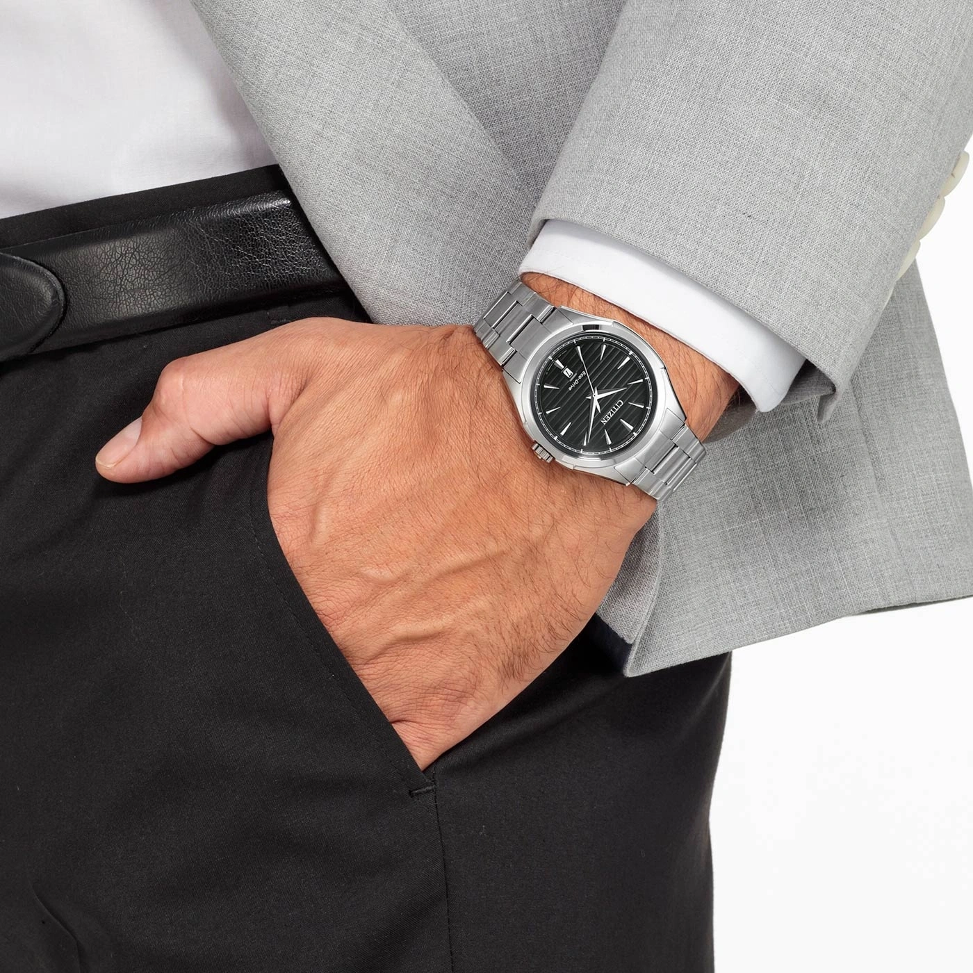 Mann mit Uhr, Anzug und schwarzer Hose, Hand in der Tasche.