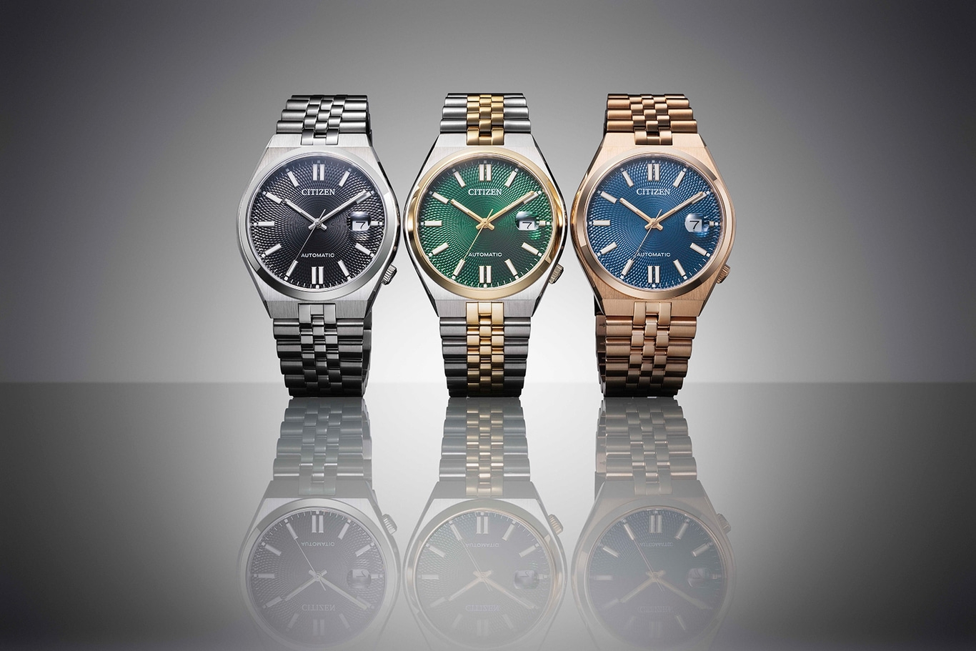 Drei Citizen-Uhren mit verschiedenfarbigen Zifferblättern und Armbändern, gespiegelt.