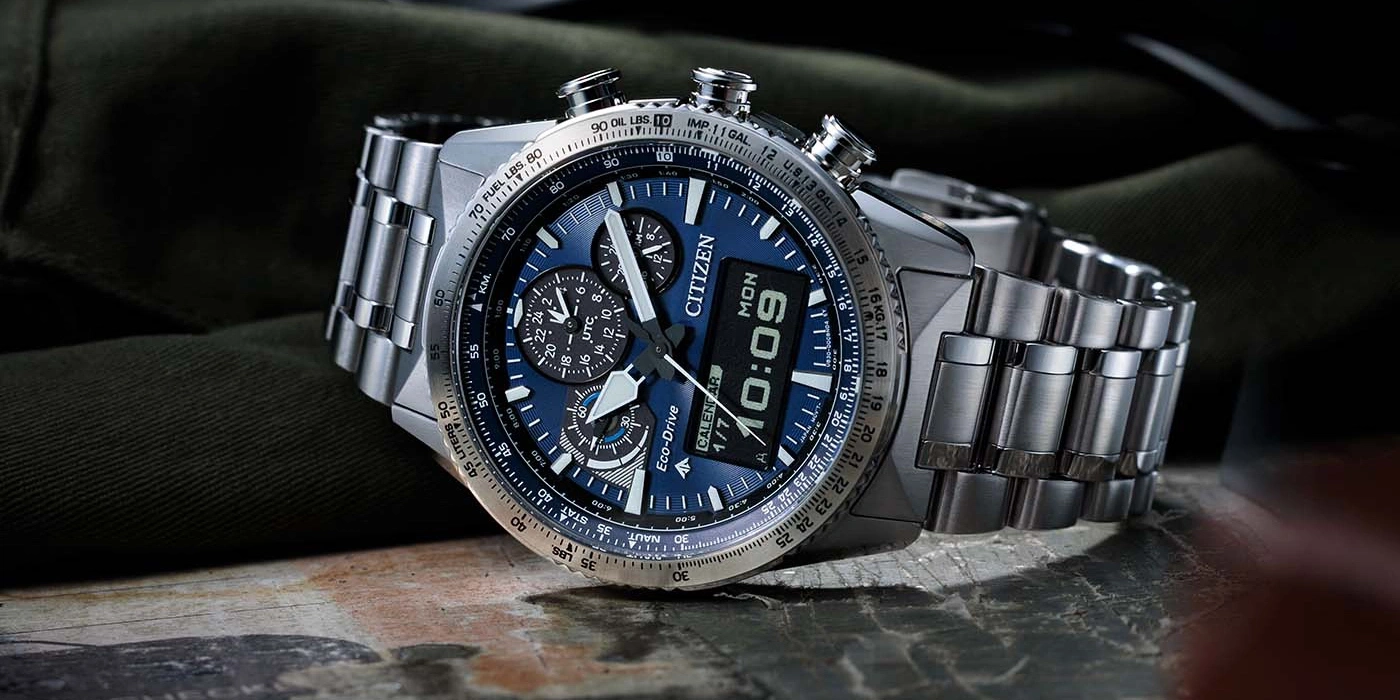 Citizen-Uhr mit blauem Zifferblatt, Digitalanzeige und Edelstahlarmband auf einer Oberfläche.