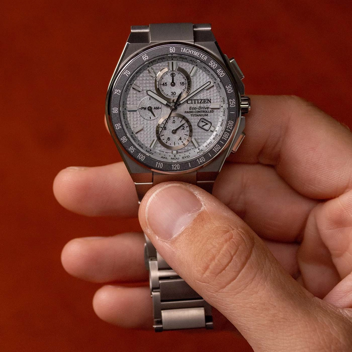 Ein Mann hält eine Citizen Eco-Drive Uhr mit silbernem Zifferblatt