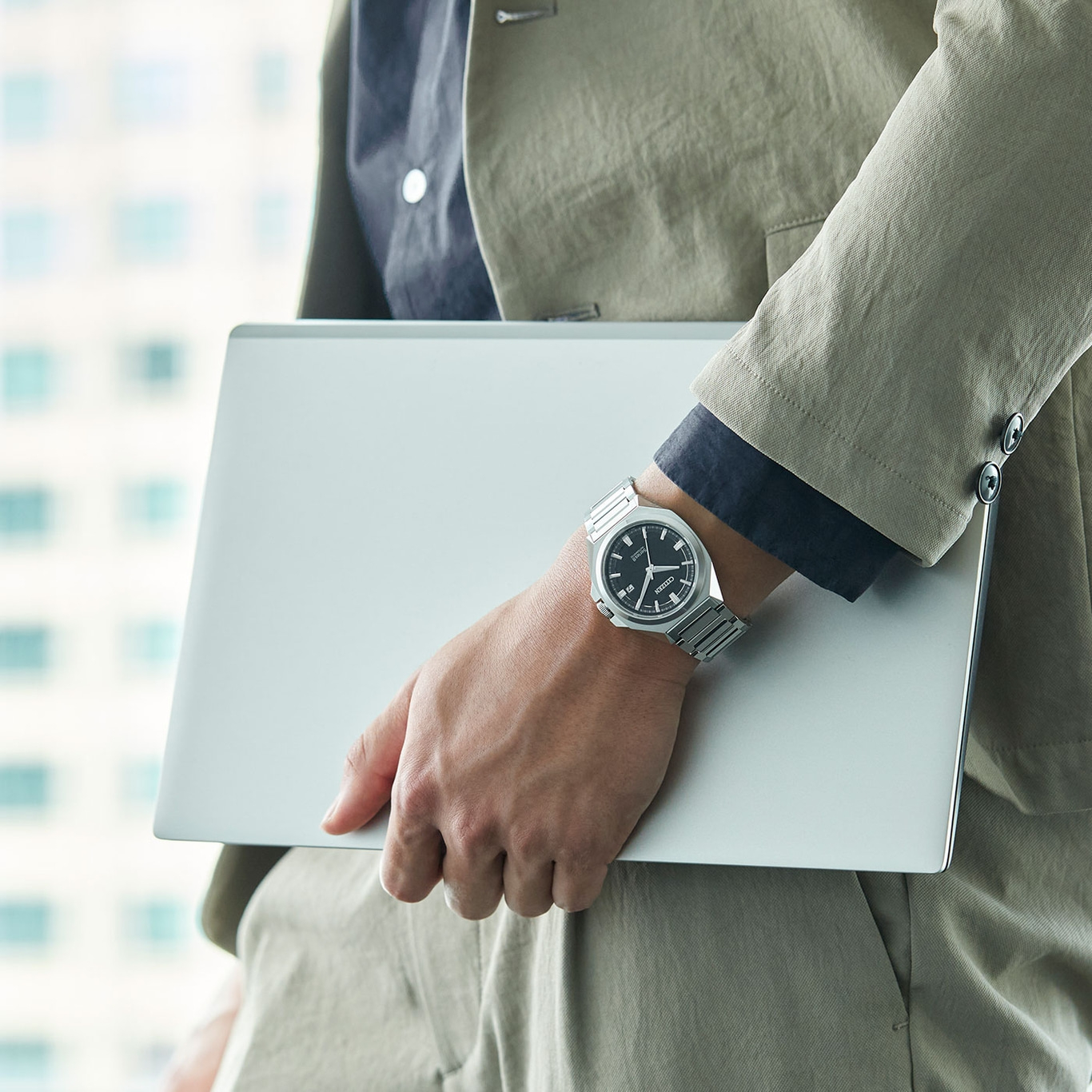 Mann hält Laptop, trägt Uhr und Anzug. Geschäftsmann.