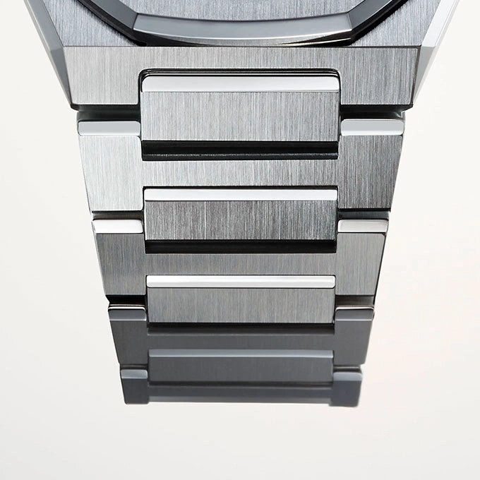 Nahaufnahme eines metallischen Uhrenarmbands mit gebürsteter Metalloberfläche und weißen Akzenten.