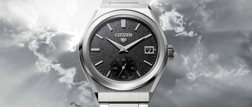 Citizen-Uhr mit schwarzem Zifferblatt und Datumsanzeige vor bewölktem Himmel.