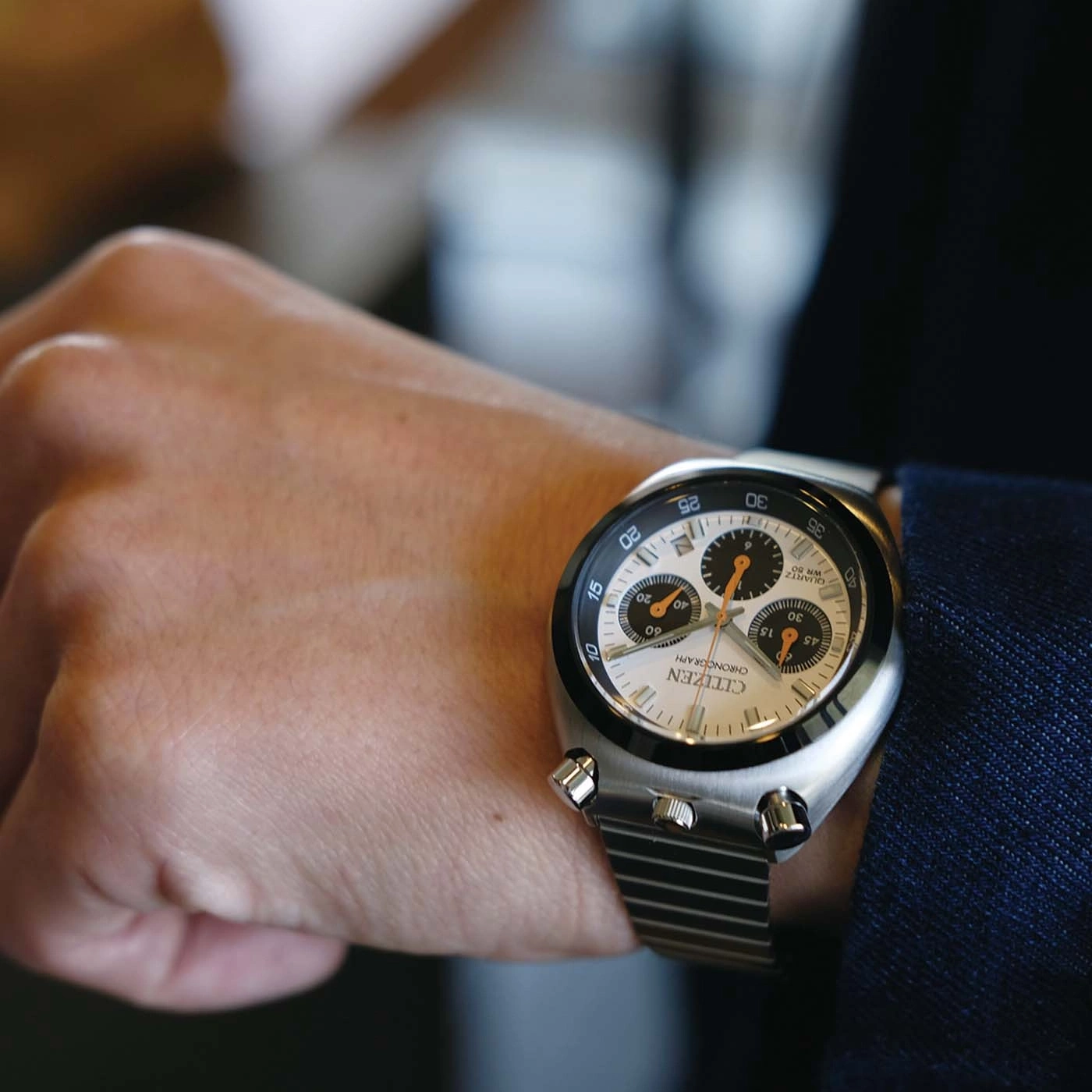 Das Handgelenk eines Mannes mit einer silbernen Citizen-Chronographenuhr.