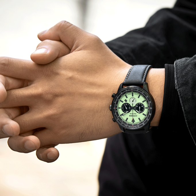 Mann trägt Citizen-Uhr mit schwarzem Armband und schwarzer Jacke.