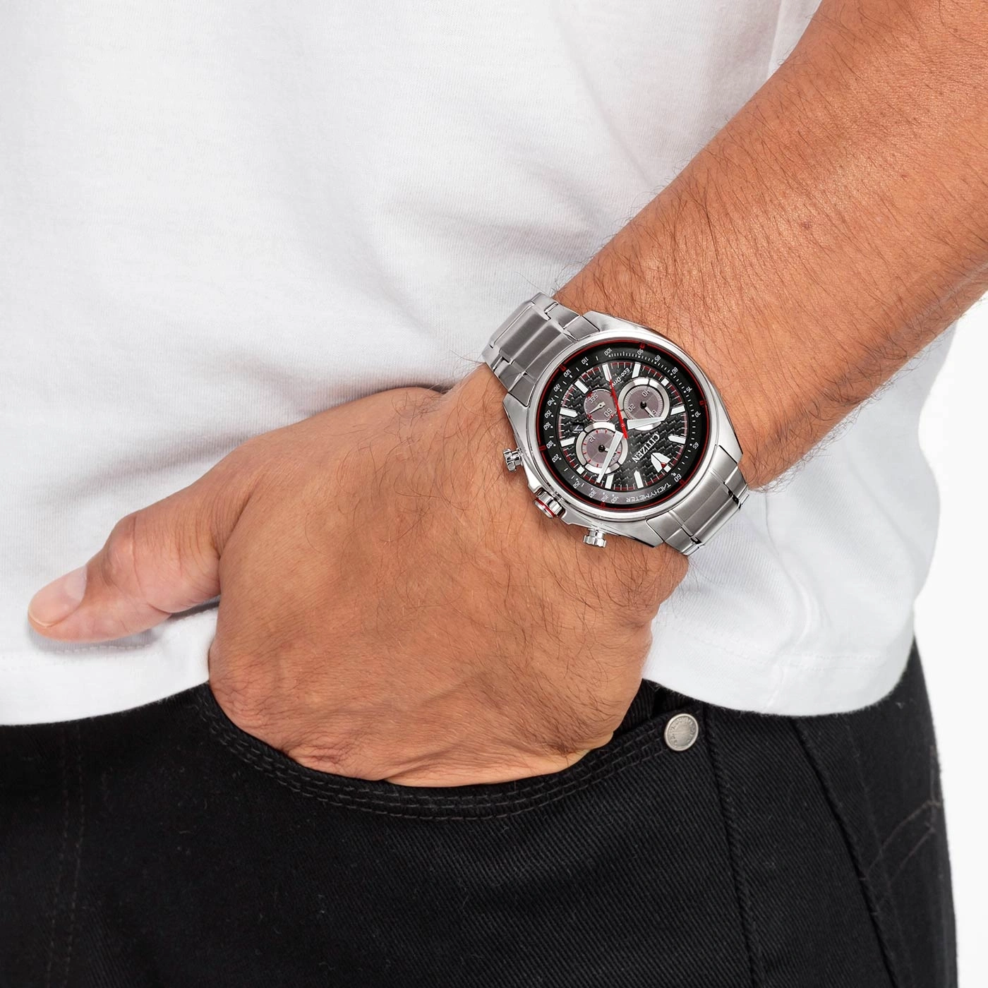 Mann mit silberner Citizen-Uhr, weißem Hemd, schwarzer Jeans, Hand in der Tasche.