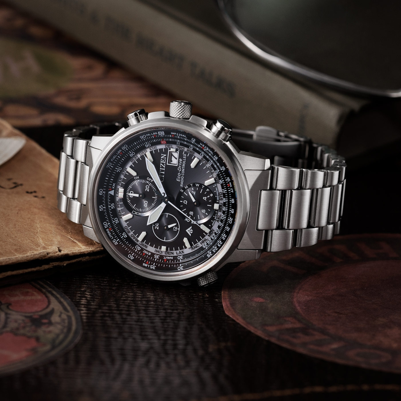 Citizen-Uhr mit schwarzem Zifferblatt und silbernem Armband auf Holzoberfläche.