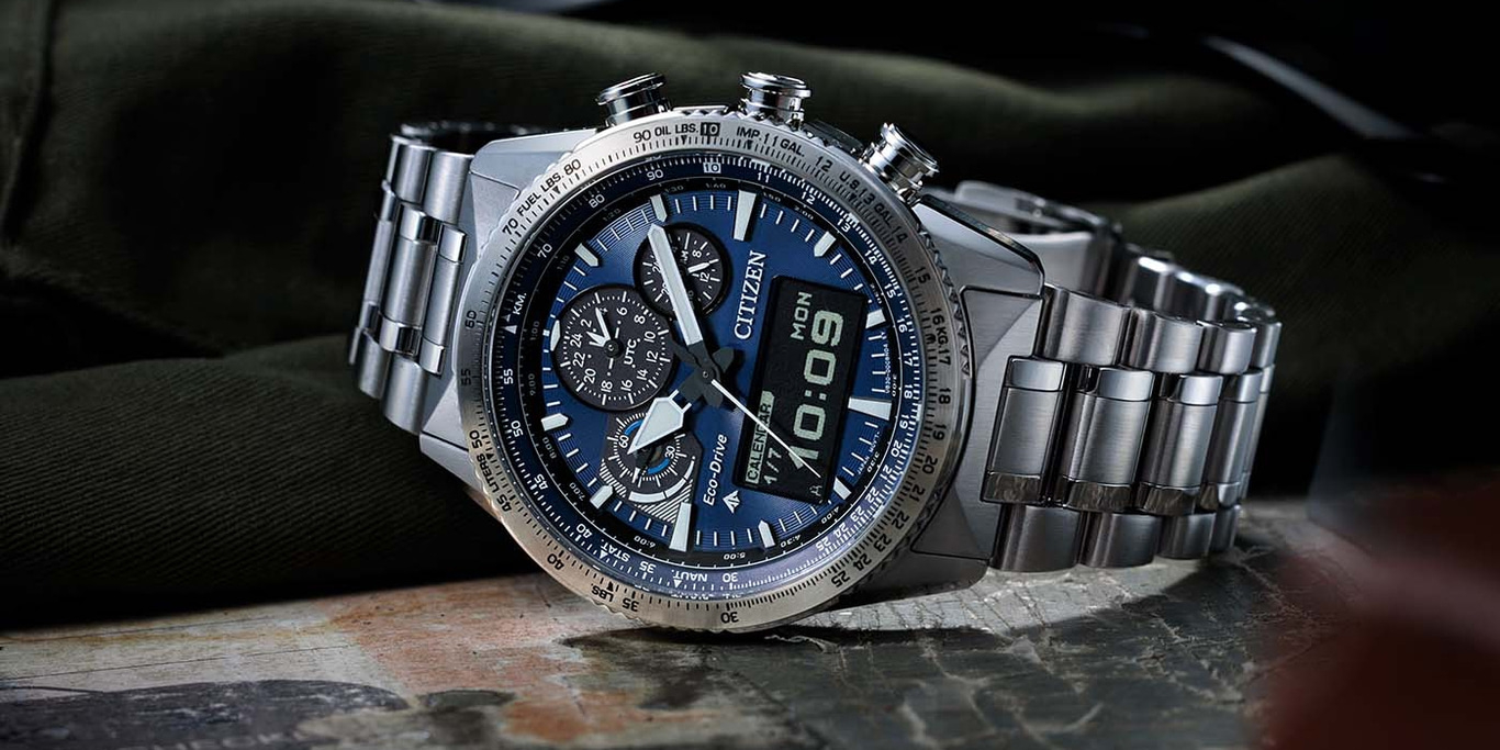 Citizen-Uhr mit blauem Zifferblatt, Digitalanzeige und Edelstahlarmband auf einer Oberfläche.