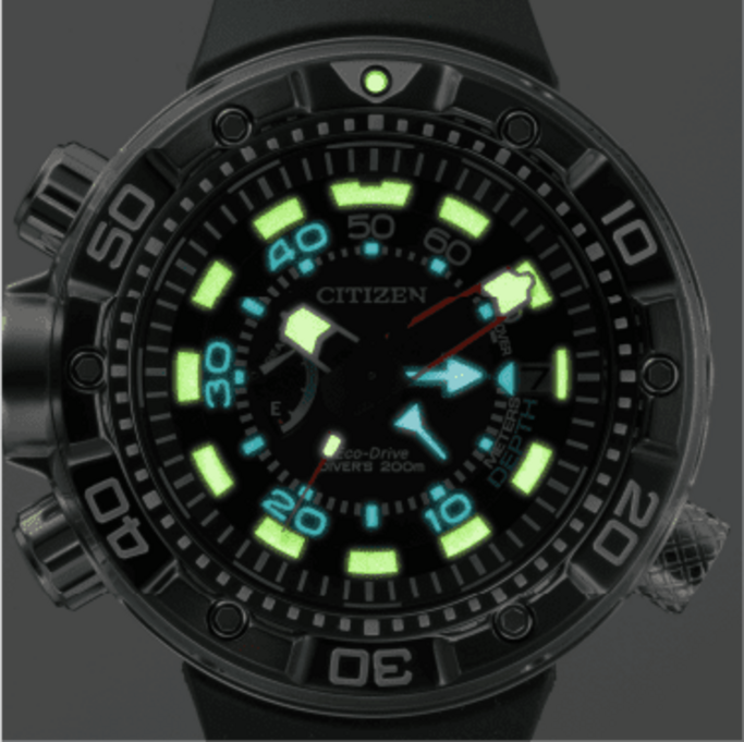 Nahaufnahme einer Citizen Eco-Drive Taucheruhr mit leuchtenden Zeigern und Markierungen, schwarze Lünette.