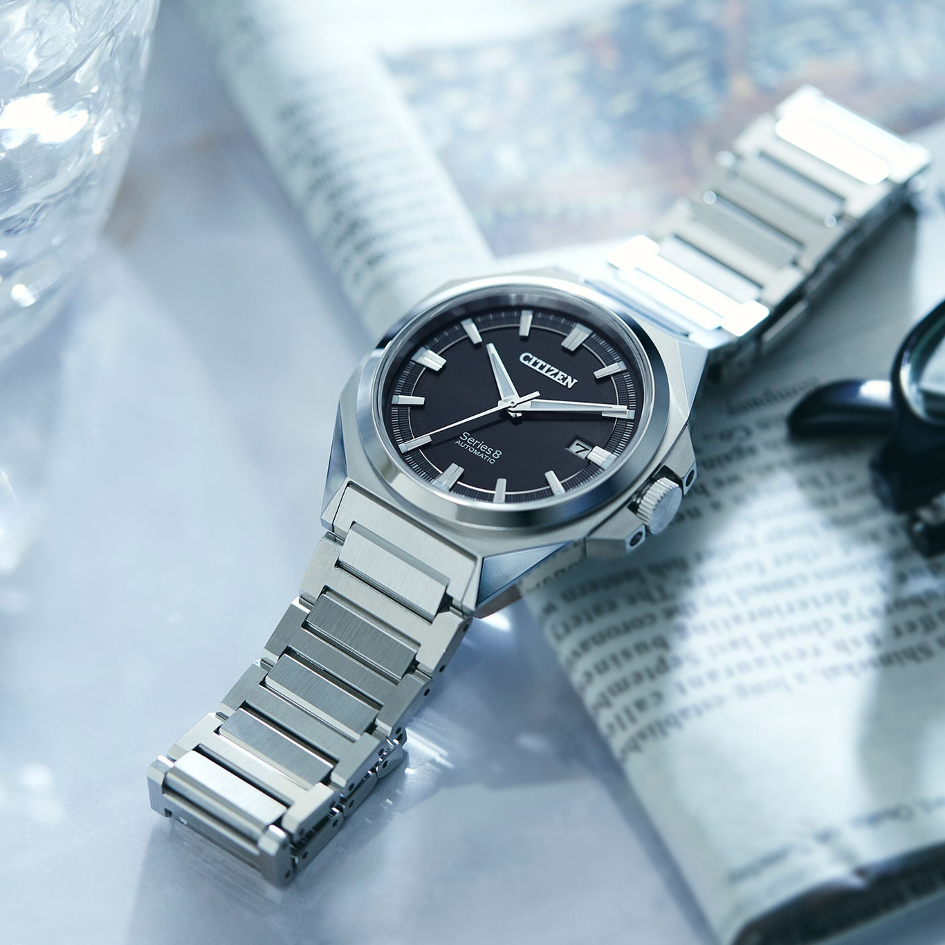 Citizen Series 8 Uhr auf Zeitung, schwarzes Zifferblatt, silbernes Armband, elegantes Design