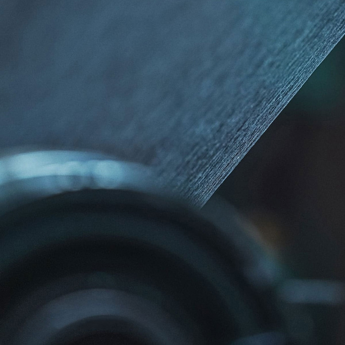 Nahaufnahme einer strukturierten, dunkelblauen Oberfläche mit unscharfem Hintergrund und Glanzlichtern.