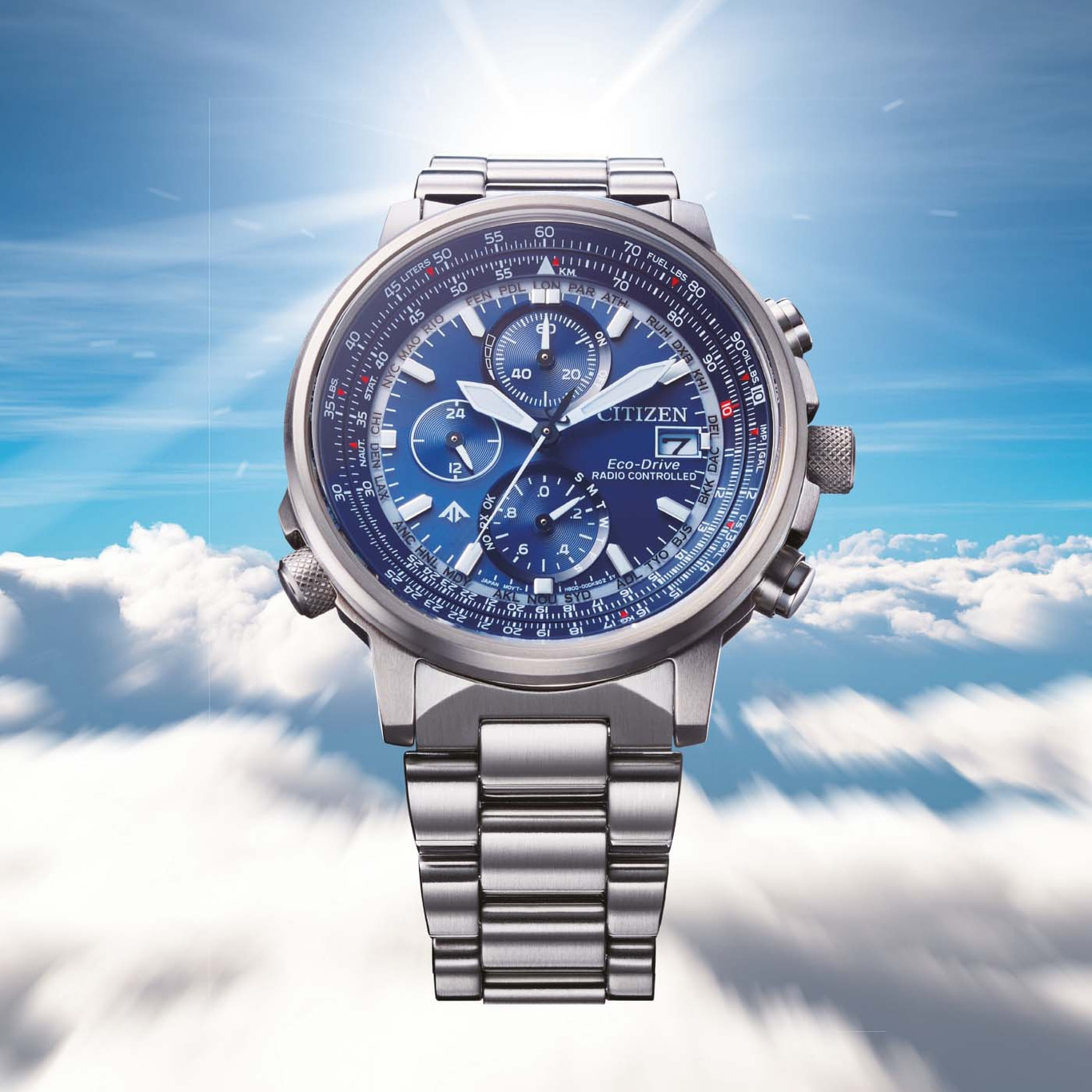 Citizen-Uhr mit blauem Zifferblatt, Edelstahlband und Himmels Hintergrund.