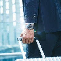 Mann im Anzug mit Uhr, der Gepäck hält, Geschäftsreisekonzept.