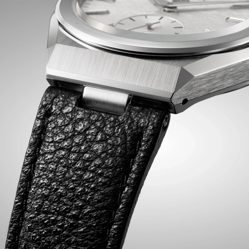 Nahaufnahme einer Luxusuhr mit schwarzem Lederarmband und silbernen Details.