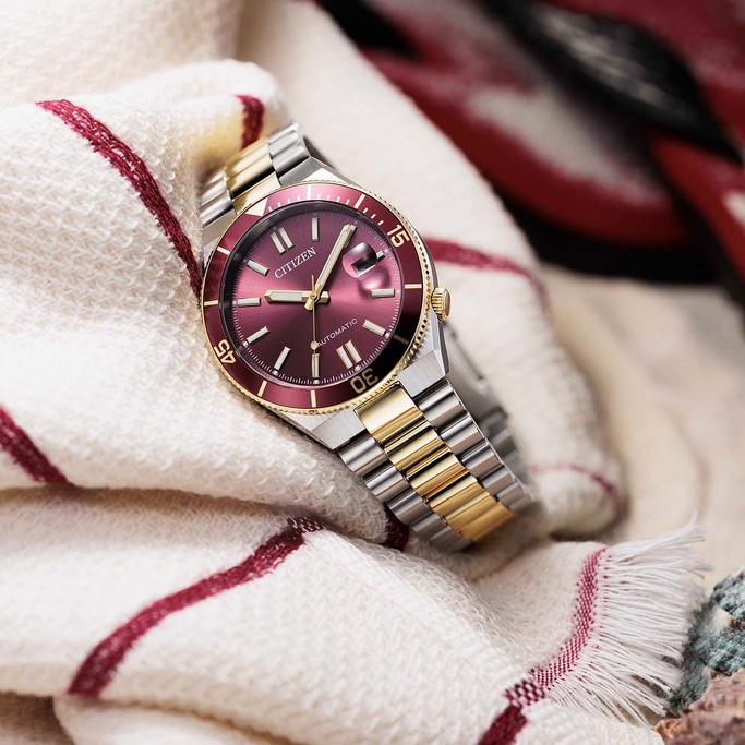 Nahaufnahme einer Citizen Automatik-Uhr mit rotem Zifferblatt und goldenen Akzenten.