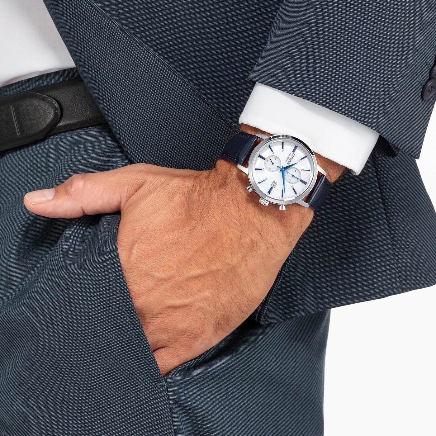 Mann mit Uhr und Anzug, der seine Hand in die Tasche steckt.