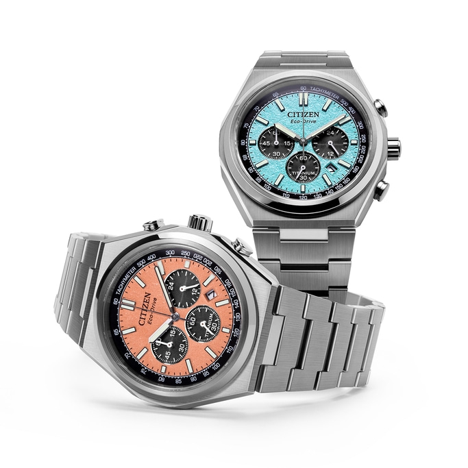 Zwei Citizen Eco-Drive Uhren mit Titanarmbändern und farbenfrohen Zifferblättern.