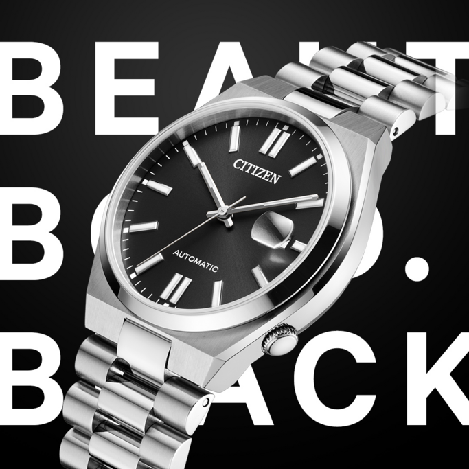 Eine silberne Citizen-Automatik-Armbanduhr mit schwarzem Zifferblatt wird vor einem schwarzen Hintergrund mit großer weißer Schrift "BEAUT BACK" dargestellt.
