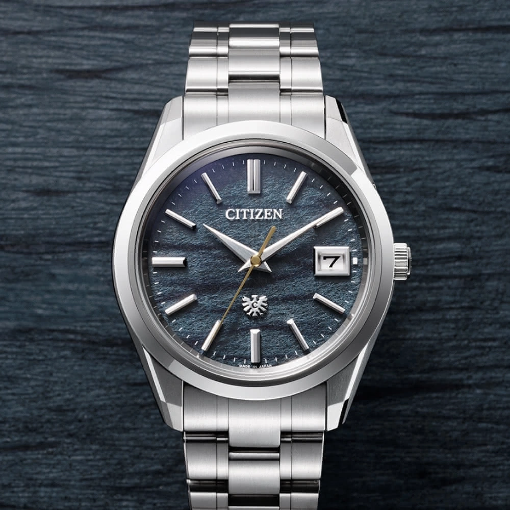 Citizen-Uhr mit blauem Zifferblatt und silbernem Armband auf dunklem Hintergrund