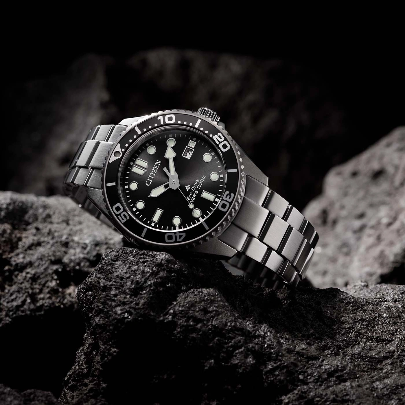 Citizen-Uhr auf einem Felsen. Schwarzes Zifferblatt, silbernes Armband. Eco-Drive, Taucher 200m.