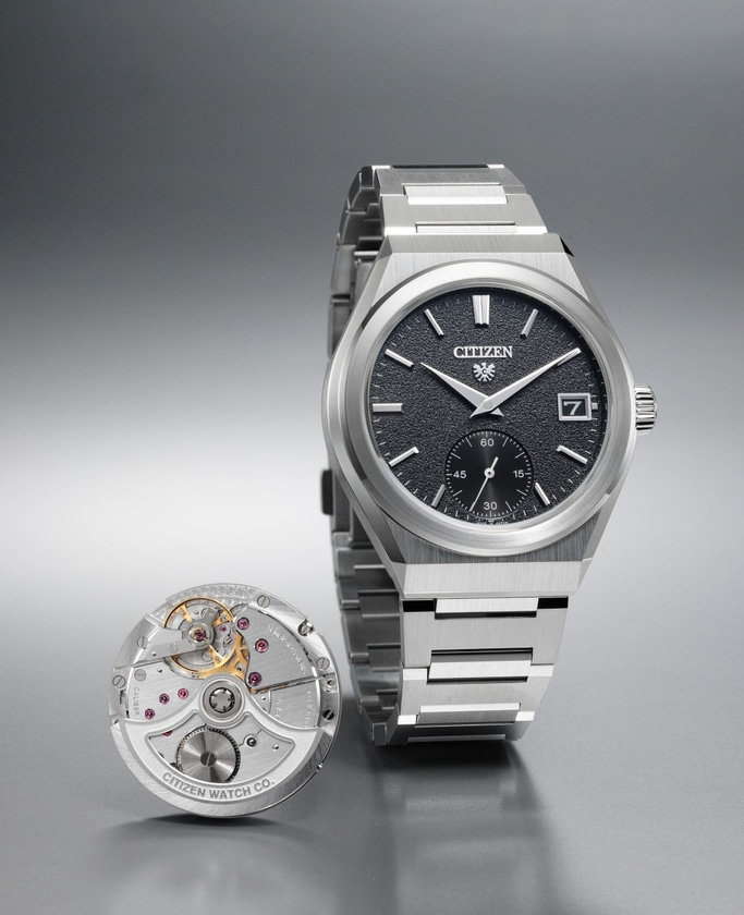 This image showcases a Citizen watch with a silver-toned integrated bracelet and a textured black dial, featuring a date window and sub-seconds. Beside it, the intricate mechanical movement is displayed, highlighting both the watch's elegant design.