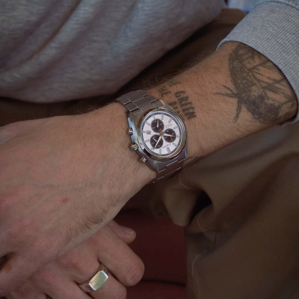 Das Handgelenk eines Mannes mit einer Uhr und einem Ring.