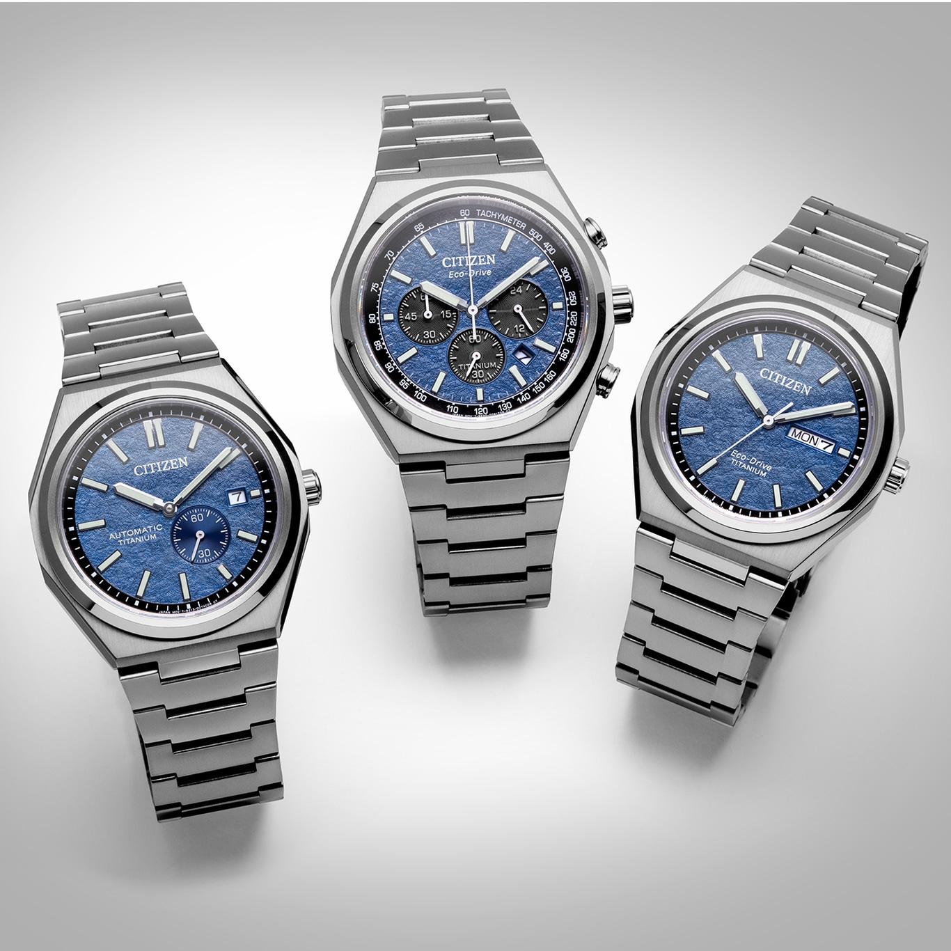 Drei Citizen-Uhren mit blauen Zifferblättern und Titanbändern auf weißem Untergrund.