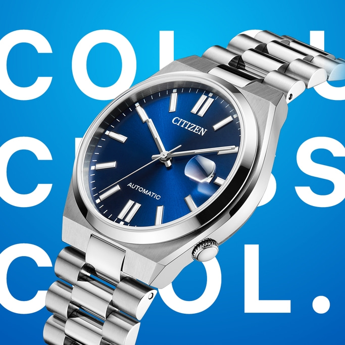 Nahaufnahme einer Citizen-Automatikuhr mit blauem Zifferblatt und silbernem Armband vor blauem Hintergrund mit weißer Aufschrift "COOL.".
