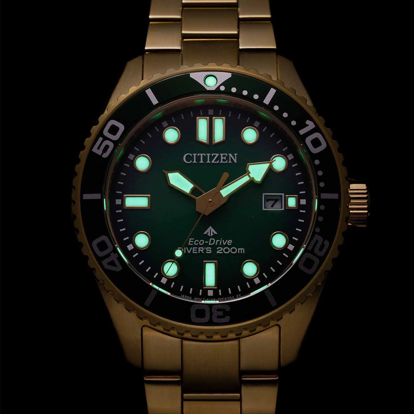Citizen-Uhr mit grünem Zifferblatt und goldenem Armband, die im Dunkeln leuchtet.