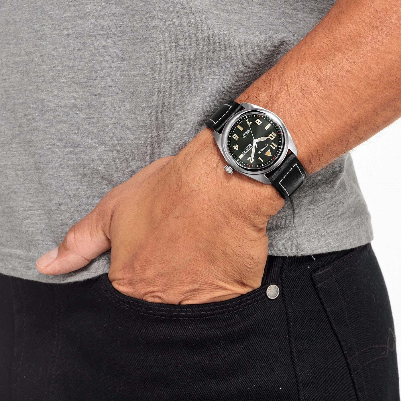 Mann mit Uhr, Hand in der Tasche, graues Hemd, schwarze Jeans, Nahaufnahme