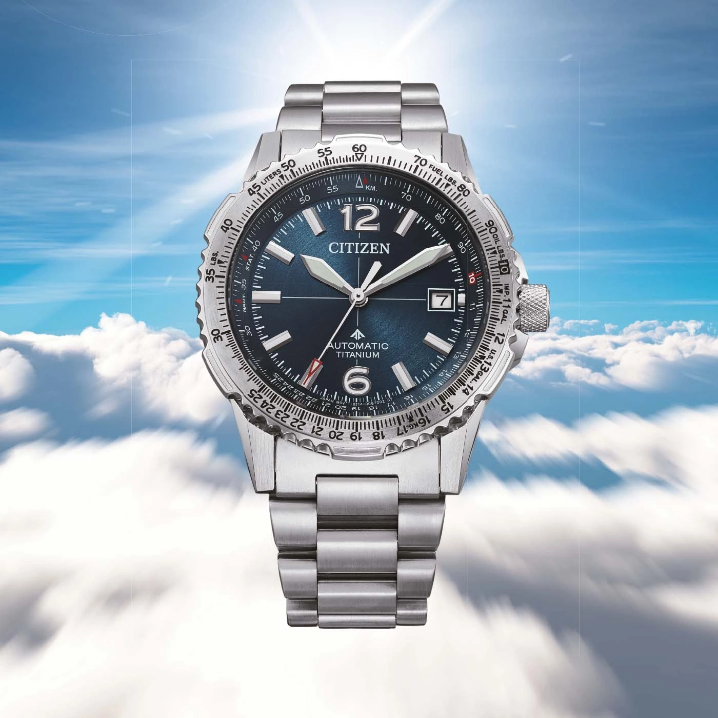 Eine Citizen-Uhr mit blauem Zifferblatt und silbernem Armband schwebt am Himmel.