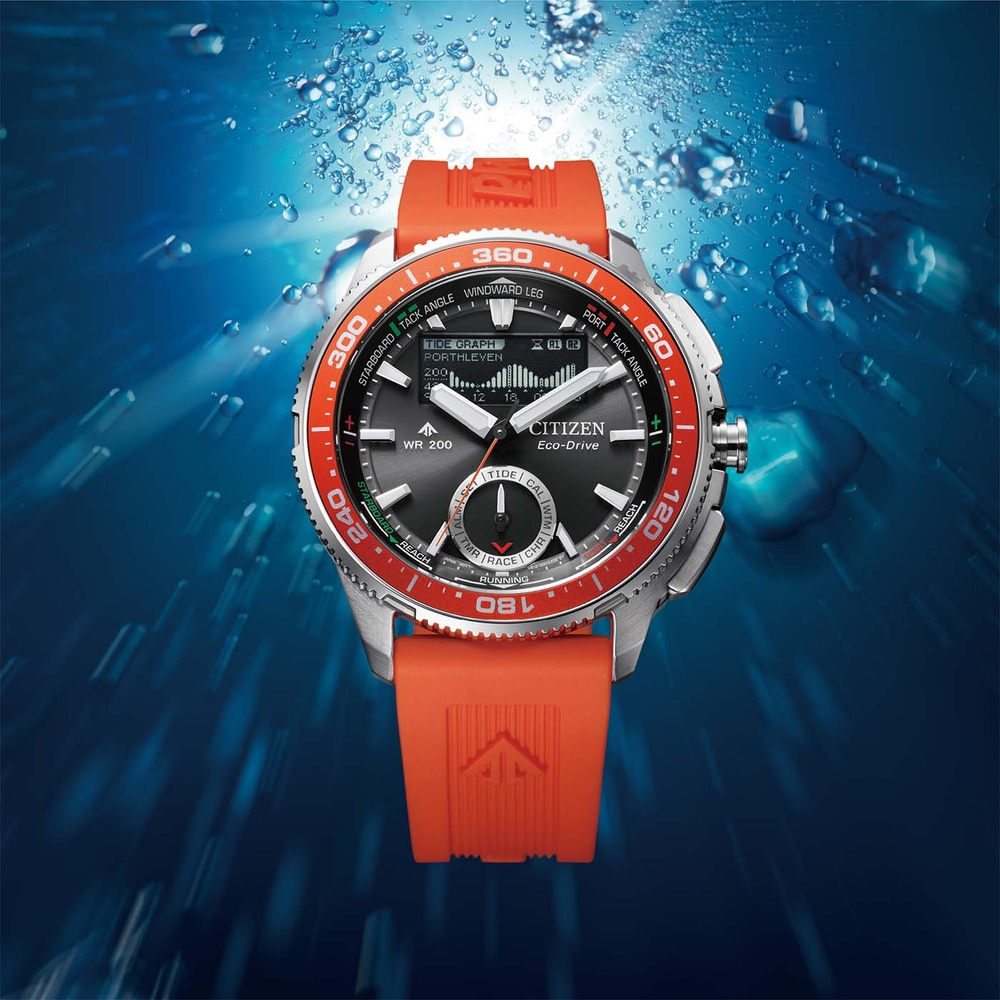 Eine Taucheruhr mit orangefarbenem Band in blauem Wasser.