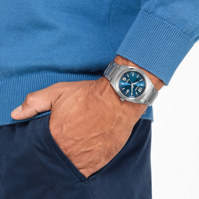 Mann mit blauer Uhr und Pullover, Hand in der Tasche.