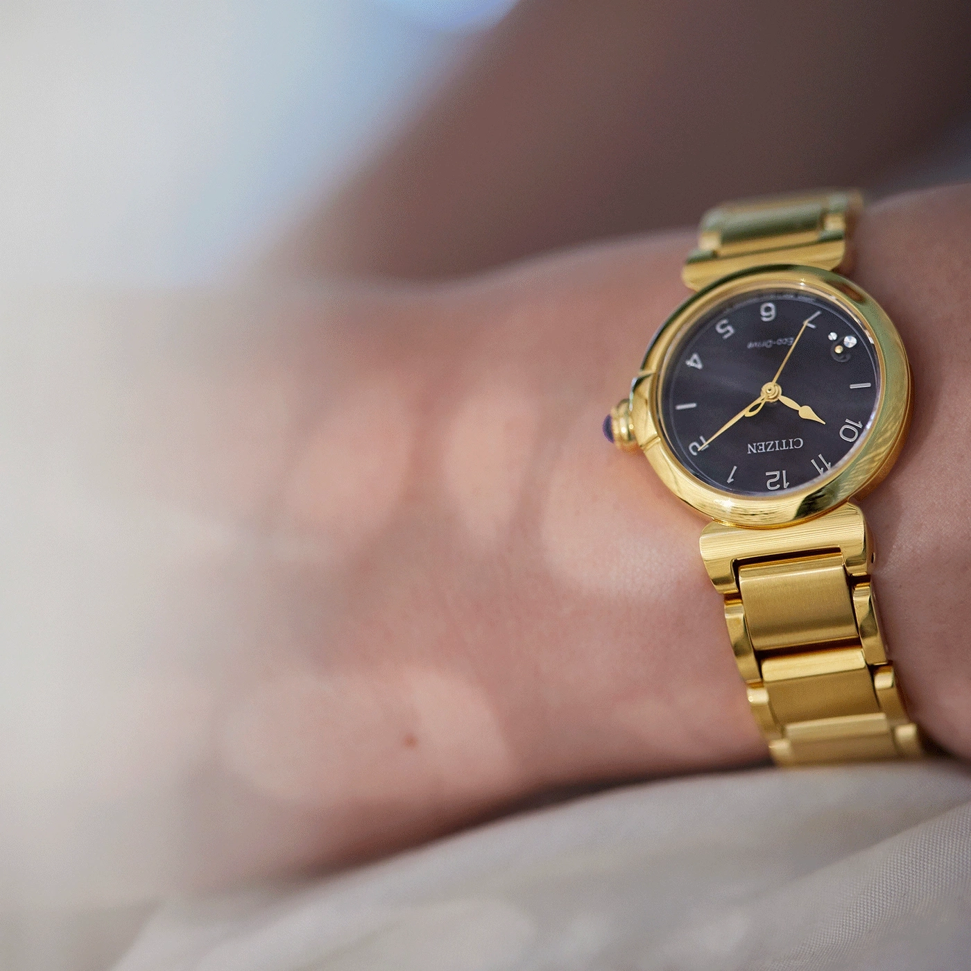 Nahaufnahme einer goldenen Citizen-Uhr am Handgelenk, elegant und stilvoll.