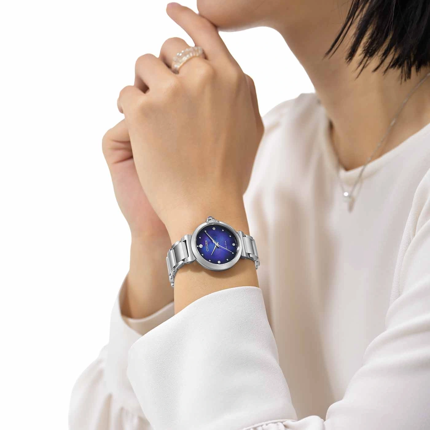 Frau mit silberner Uhr mit blauem Zifferblatt und Diamanten