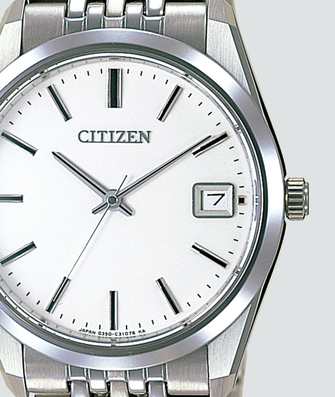 This close-up image features a Citizen watch with a clean white dial, silver-toned case, and metal bracelet. It displays thin black hour markers, sleek hands, and a date window at 3 o'clock, exuding a minimalist and timeless elegance.