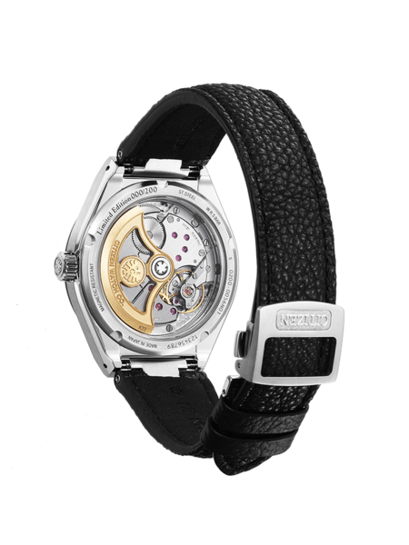 This image shows the transparent caseback of a Citizen watch, revealing its intricate mechanical movement with golden components and ruby jewels. It has a black leather strap with a 'CITIZEN' clasp, against a grey background.