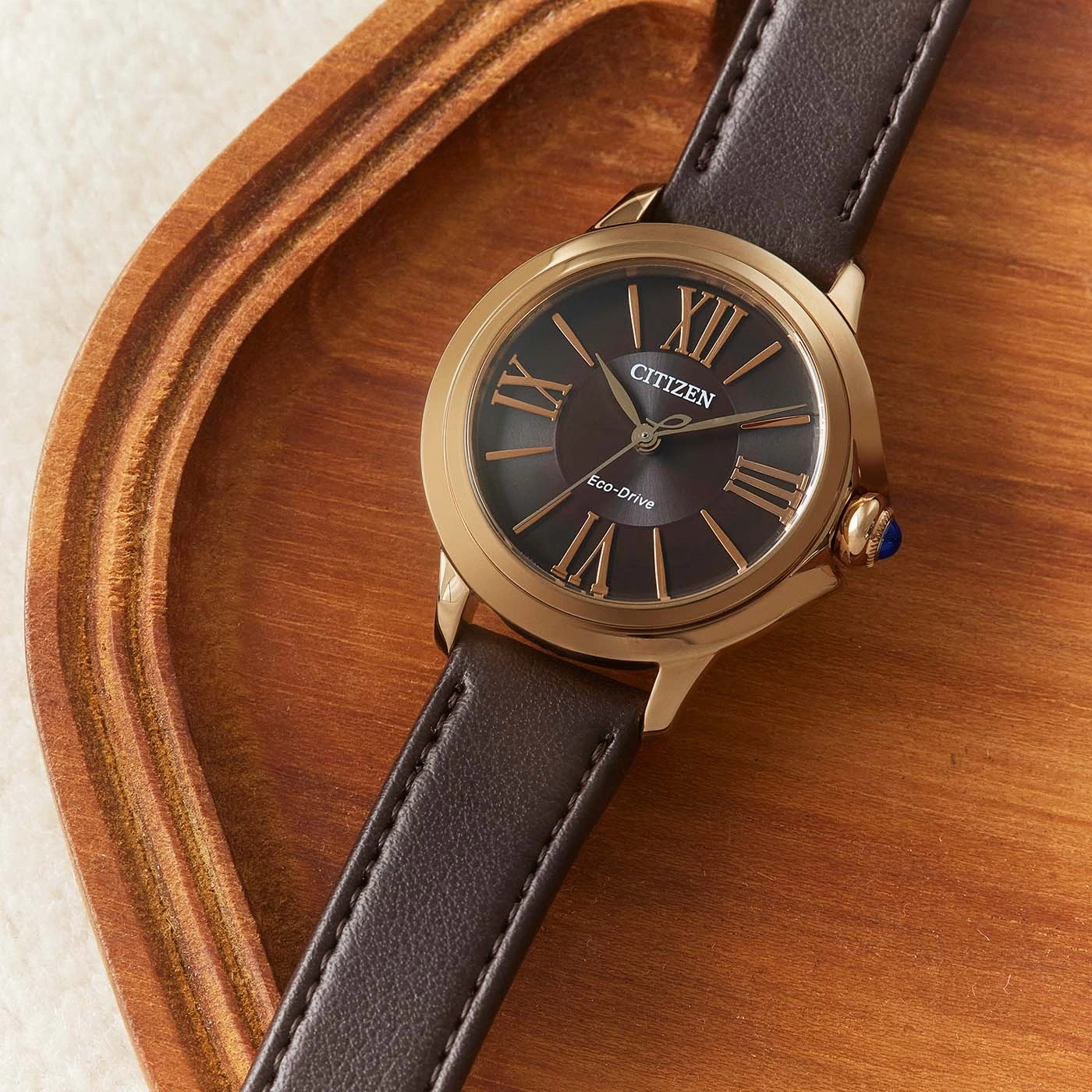 Citizen-Uhr mit braunem Lederarmband auf Holztablett